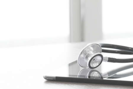 studio macro of a stethoscope and digital tablet on wood table background copy spaceの写真素材