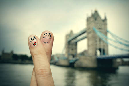 the happy finger couple in love with painted smiley on london city blurred backgroundの写真素材