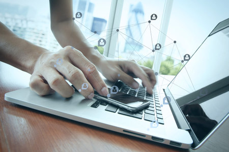 businessman hand working with smart phone with laptop computer and london city blurred background...