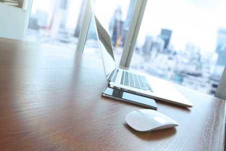 mouse and laptop computer is on wooden desk as workplace concept with overcast effect