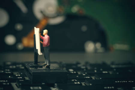 Big data concept-miniature engineer working with drafting table with open hard disk backgroundの写真素材