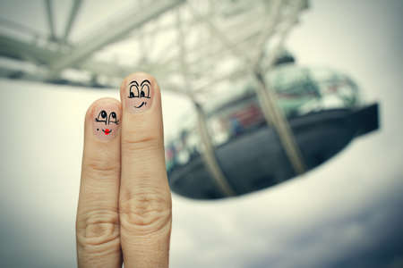 the happy finger couple in love with painted smiley on london city blurred backgroundの写真素材