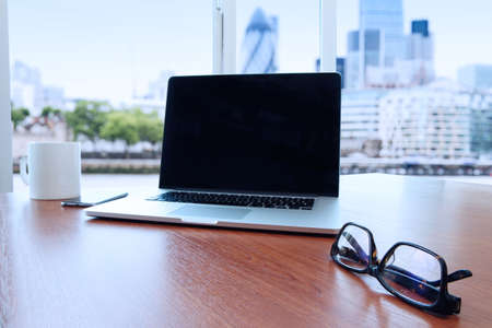 business documents on office table with laptop and smart phone as work space business concept with london city blurred backgroundの写真素材