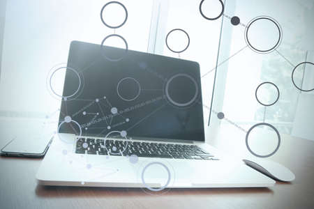 Office workplace with laptop and smart phone on wood table with social media diagramの写真素材