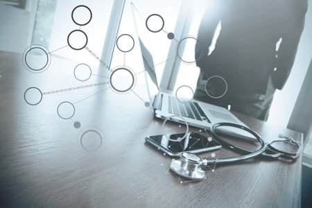 Doctor working with laptop computer in medical workspace office and overcast effect with medical...
