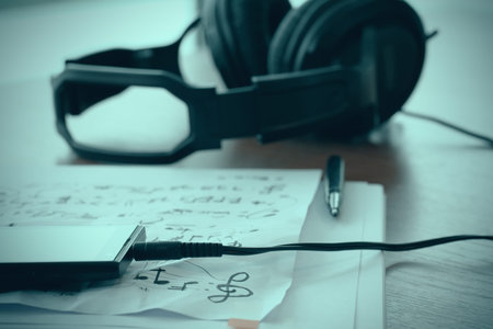 Composing music concept with shallow DOF evenly matched jack of headphone and crumpled musical notes paperの写真素材