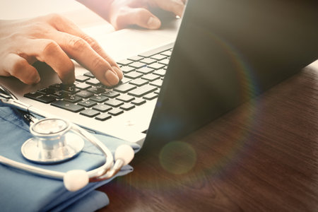 Doctor hand working with laptop computer in medical workspace office as concept