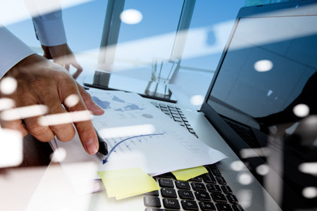 Double exposure of businessman hand working with new modern computer and business strategy as...