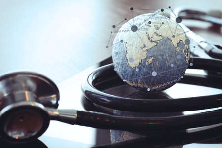 stethoscope and texture globe with digital tablet with social media network diagram as medical network conceptの写真素材