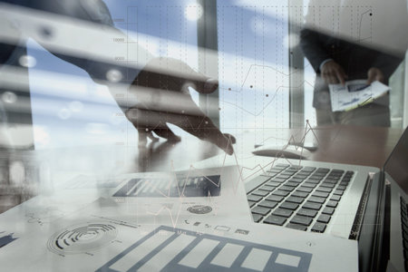 business documents on office table with smart phone and digital tablet and laptop computer and two...