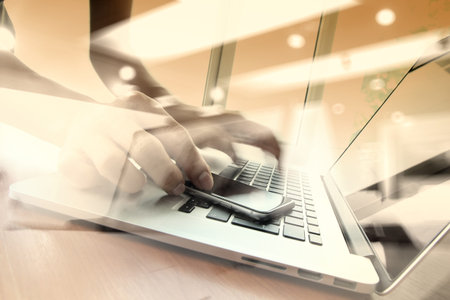 double exposure of businessman hand working with smart phone with laptop computer