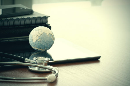 stethoscope and texture globe with digital tablet as medical network conceptの写真素材