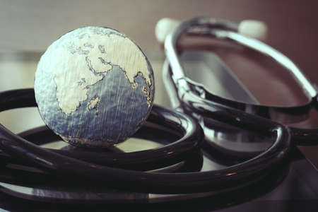 stethoscope and texture globe with digital tablet as medical network conceptの写真素材