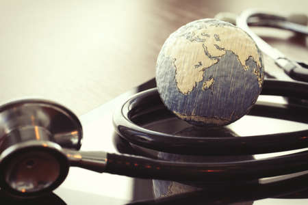 stethoscope and texture globe with digital tablet as medical network conceptの写真素材