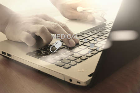 Doctor working with digital tablet and laptop computer in medical workspace office and medical network media diagram as conceptの写真素材