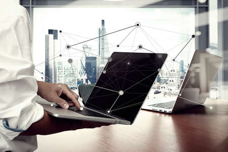business man hand working on laptop computer on wooden desk as concept and social media network diagramの写真素材