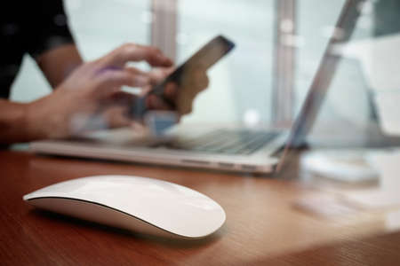 close up of business man hand working on laptop computer on wooden deskの写真素材