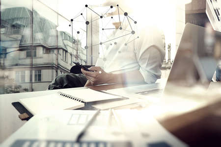 business documents on office table with smart phone and digital tablet and graph business with social network diagram and man working in the backgroundの写真素材