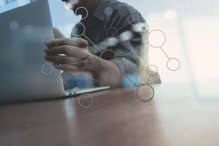 close up of business man hand working on laptop computer with social media diagram on wooden desk