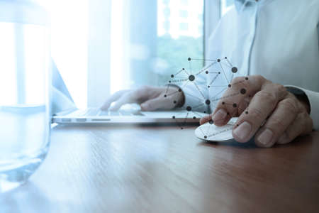 close up of business man hand working on laptop computer with social media diagram on wooden deskの写真素材