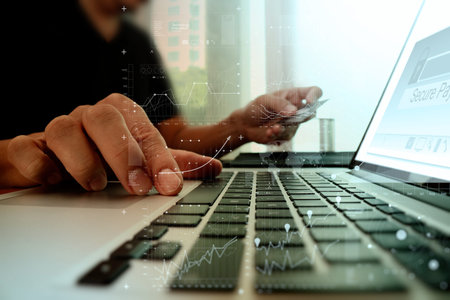 hands using laptop and holding credit card with digital business layers diagram as Online shopping conceptの写真素材