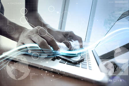 Waves of blue light and businessman using on laptop computer and smart phone with digital layer effect as conceptの写真素材
