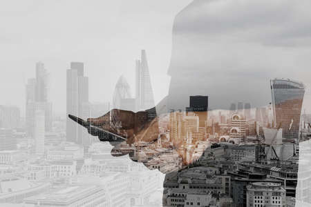 Double exposure of success businessman using digital tablet with london building and social media diagramの写真素材