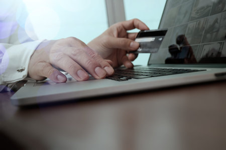 hands using laptop and holding credit card with social media diagram as Online shopping concept
