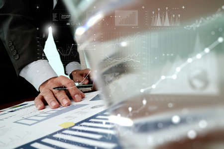 Close up of business man hand working with digital business layers diagram laptop computer on wooden desk as conceptの写真素材