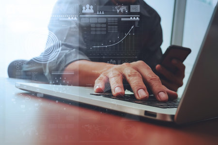 Close up of business man hand working on laptop computer with digital business strategy diagram on...