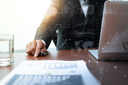 business documents on office table with smart phone and laptop computer and graph business diagram...