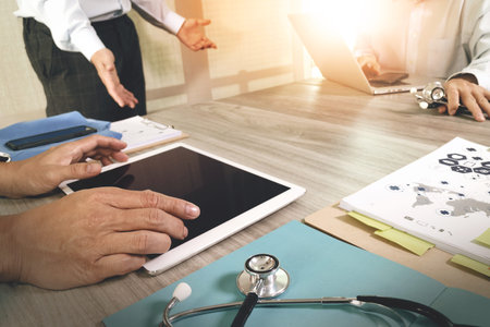 Medicine doctor hand working with modern computer and digital pro tablet with blank screen with his...