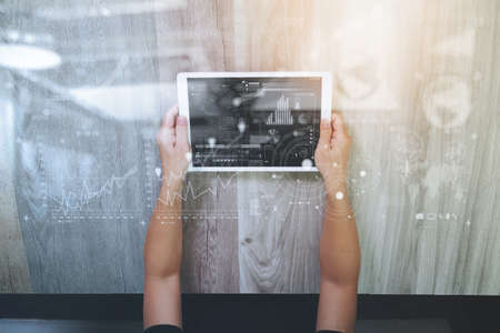 top view of Designer hand working with digital tablet computer and design diagram layer effect on wooden desk as responsive web design conceptの写真素材