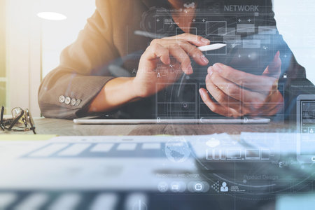 business documents on office table with digital tablet computer with smart phone and graph business digital diagram and businessman working in the backgroundの写真素材