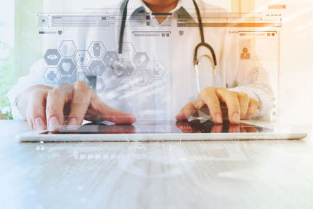 Medicine doctor hand working with modern digital tablet with computer interface as medical network conceptの写真素材