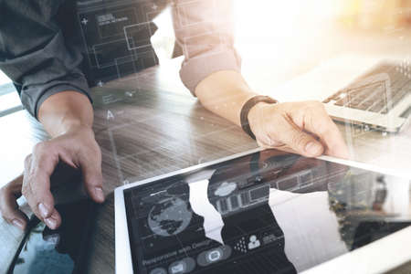 Website designer working digital tablet and computer laptop and digital design diagram on wooden desk as conceptの写真素材