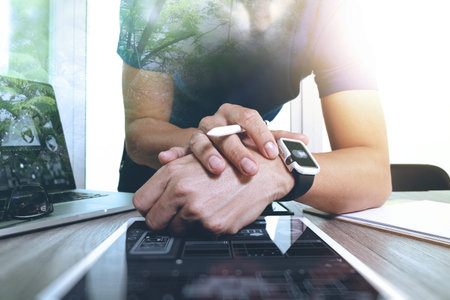 Website designer working with smart watch and digital tablet and digital design diagram on wooden desk as conceptの写真素材