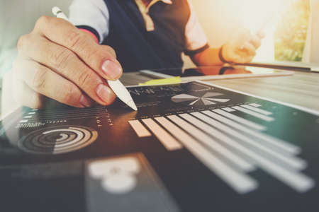 business documents on office table with smart phone and digital tablet and graph business with social network diagram and man working in the backgroundの販売画像