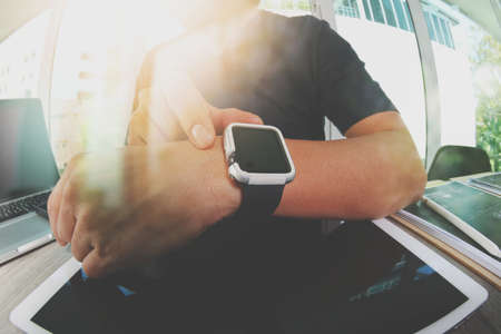 Website designer working with smart watch and digital tablet and digital design diagram on wooden desk as conceptの写真素材
