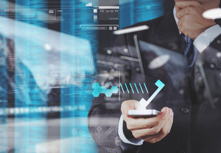 double exposure of businessman hand using the phone tablet touch computer gadget as concept