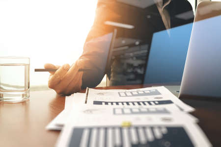 business documents on office table with laptop computer and graph business with social network diagram and man working in the backgrounの写真素材