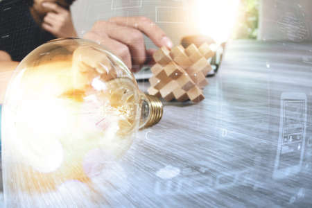 light bulb with designer hand working with laptop computer and creative business strategy as conceptの写真素材