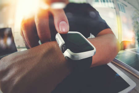 Website designer working with smart watch and digital tablet and digital design diagram on wooden desk as conceptの写真素材