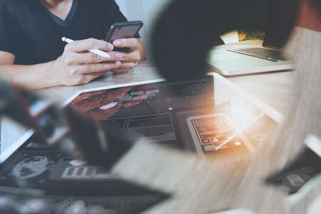 Website designer working digital tablet and computer laptop with smart phone and digital design diagram on wooden desk as conceptの写真素材