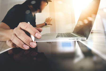 Website designer working digital tablet and computer laptop on wooden desk as conceptの写真素材