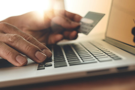close up of hands using laptop and holding credit card with social media diagram as Online shopping...