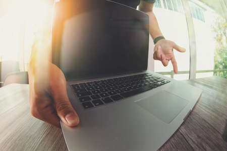 Designer hand working with laptop computer on wooden desk as responsive web design conceptの写真素材