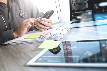 Doctor working with digital tablet and laptop computer with smart phone in medical workspace office...