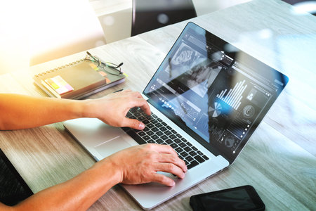 website designer hand attending video conference with laptop computer and smart phone at desk in...