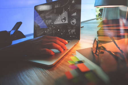 Designer hand working with laptop computer on wooden desk as responsive web design conceptの写真素材